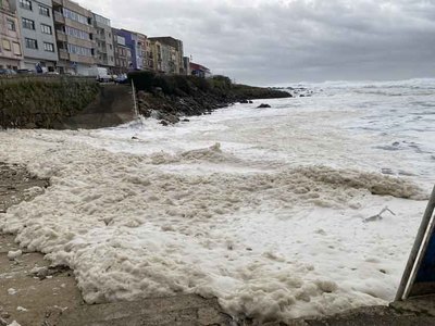 Curiosos se acercan a O Carreiro para ver la espuma generada por el fuerte oleaje en A Guarda